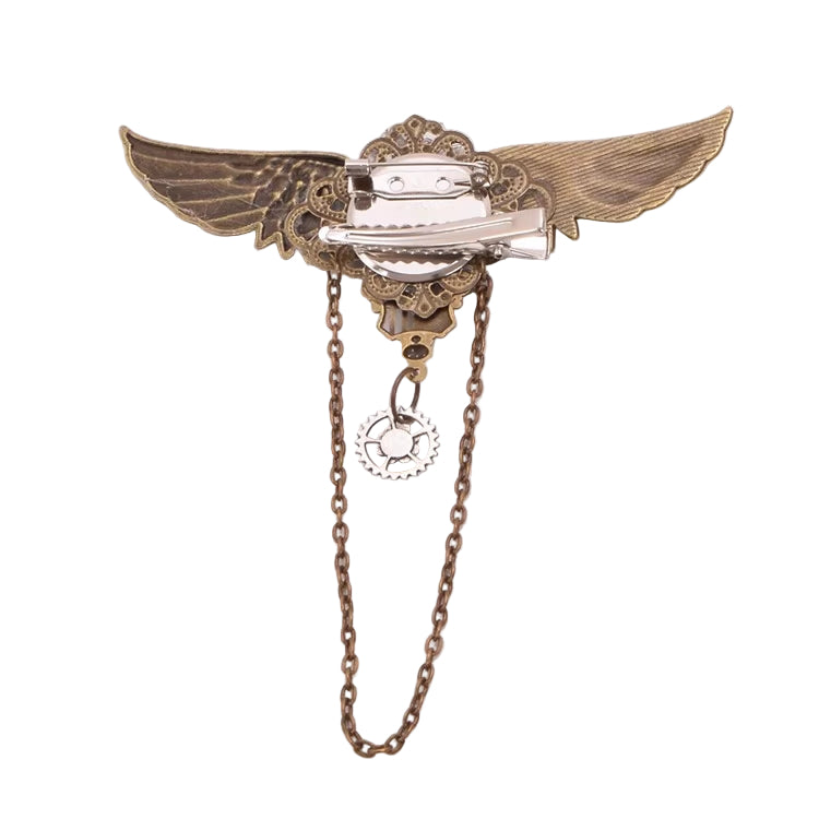 Decorative brooch with wings and chain on a light gray background